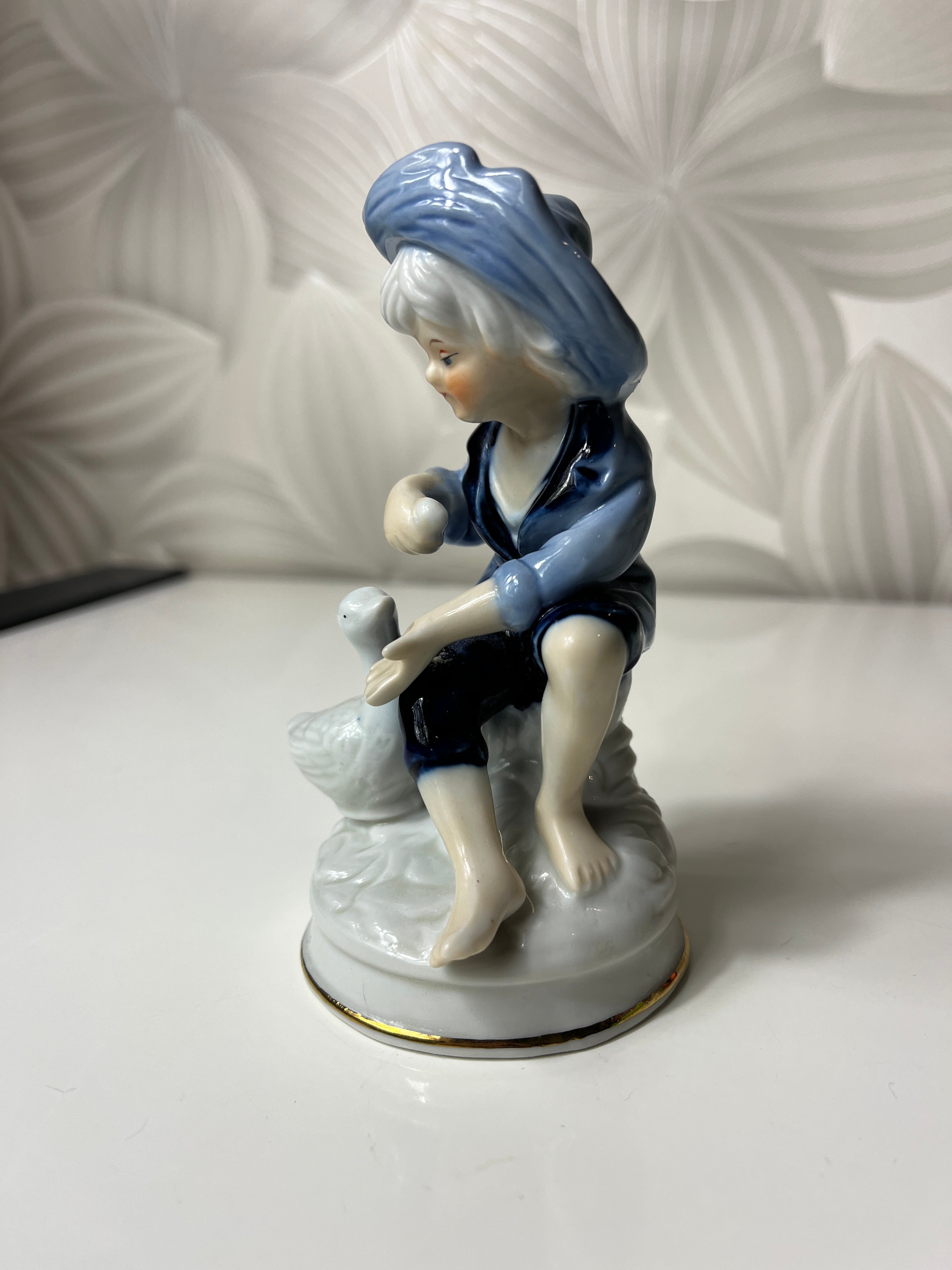 Porcelianinė berniuko su žąsimi figūrėlė