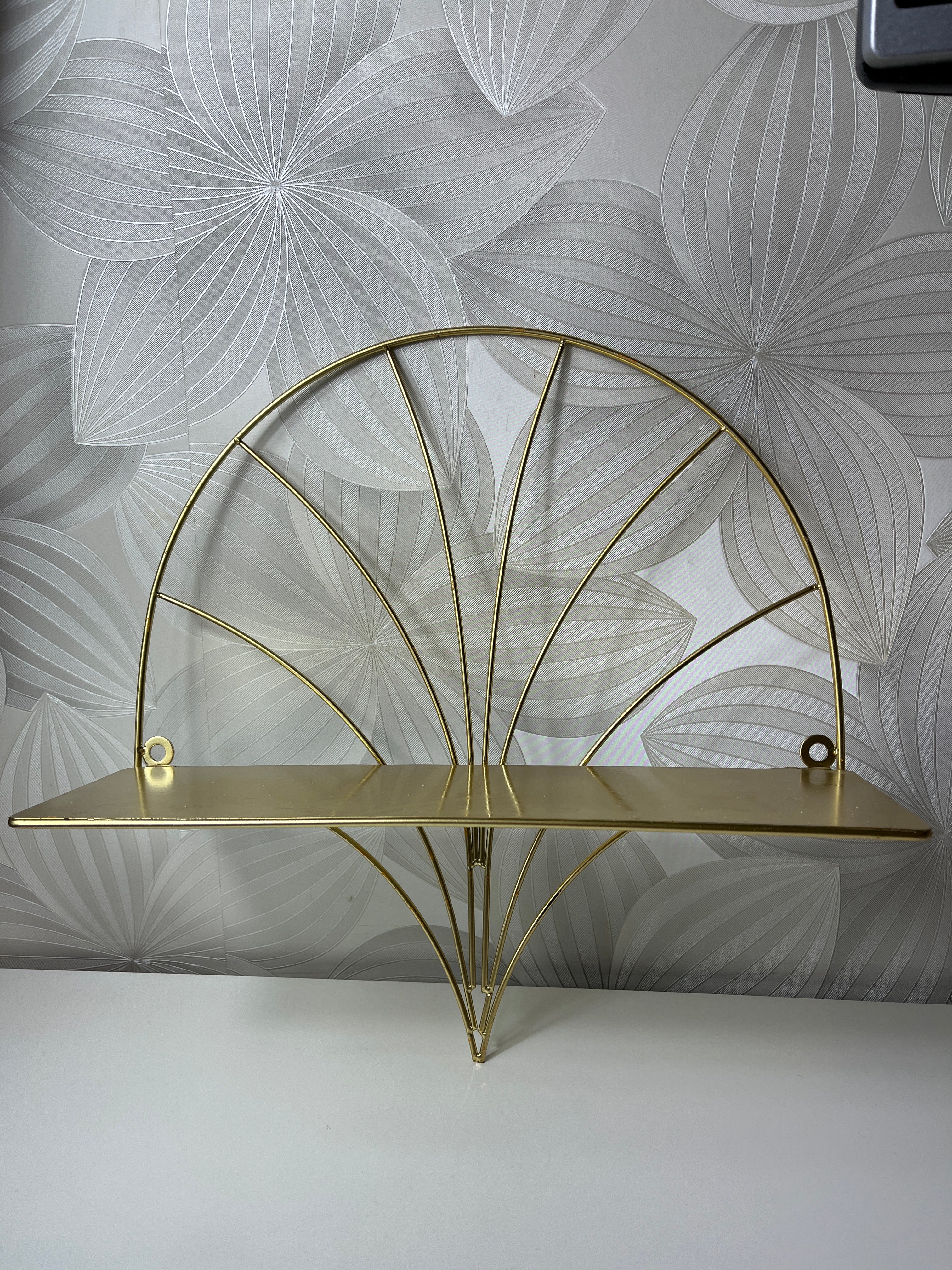 Auksinės spalvos lentyna su metaliniu rėmu