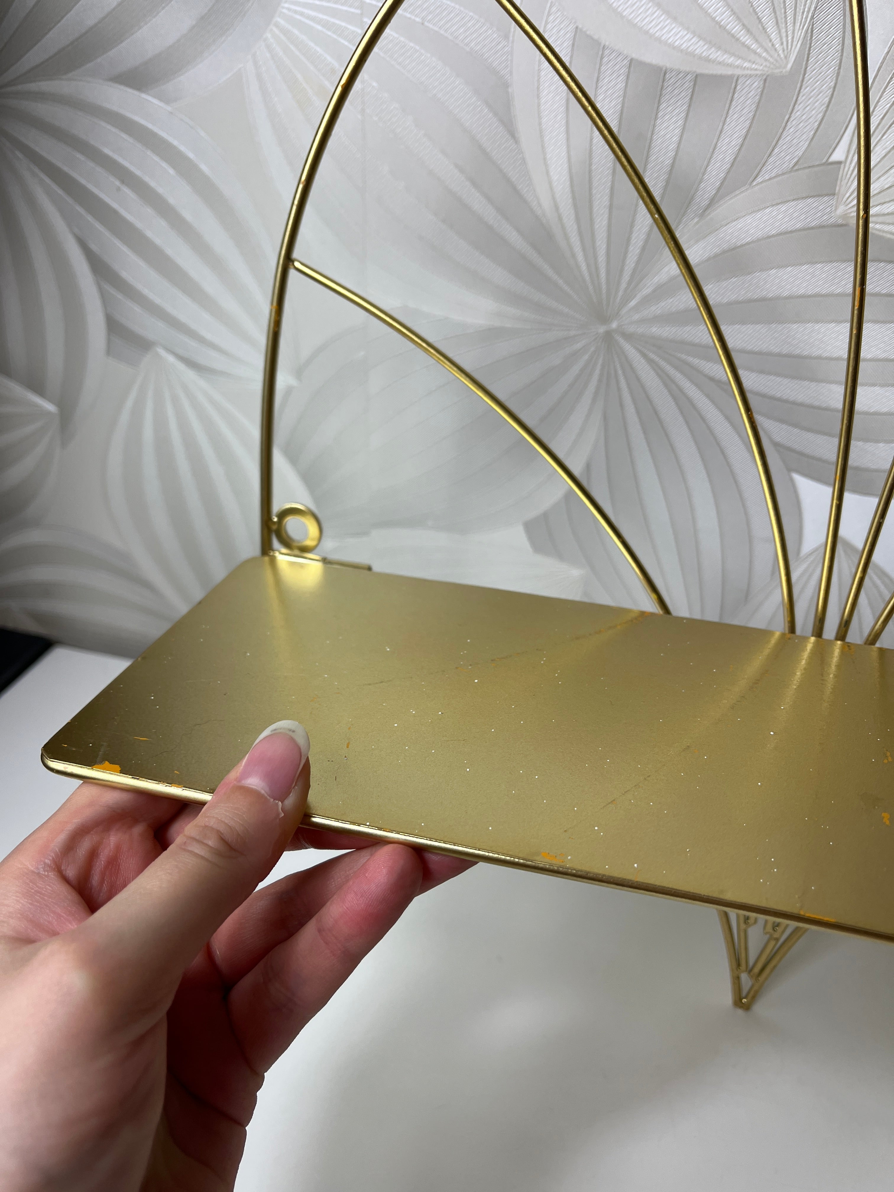 Auksinės spalvos lentyna su metaliniu rėmu