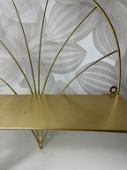 Auksinės spalvos lentyna su metaliniu rėmu