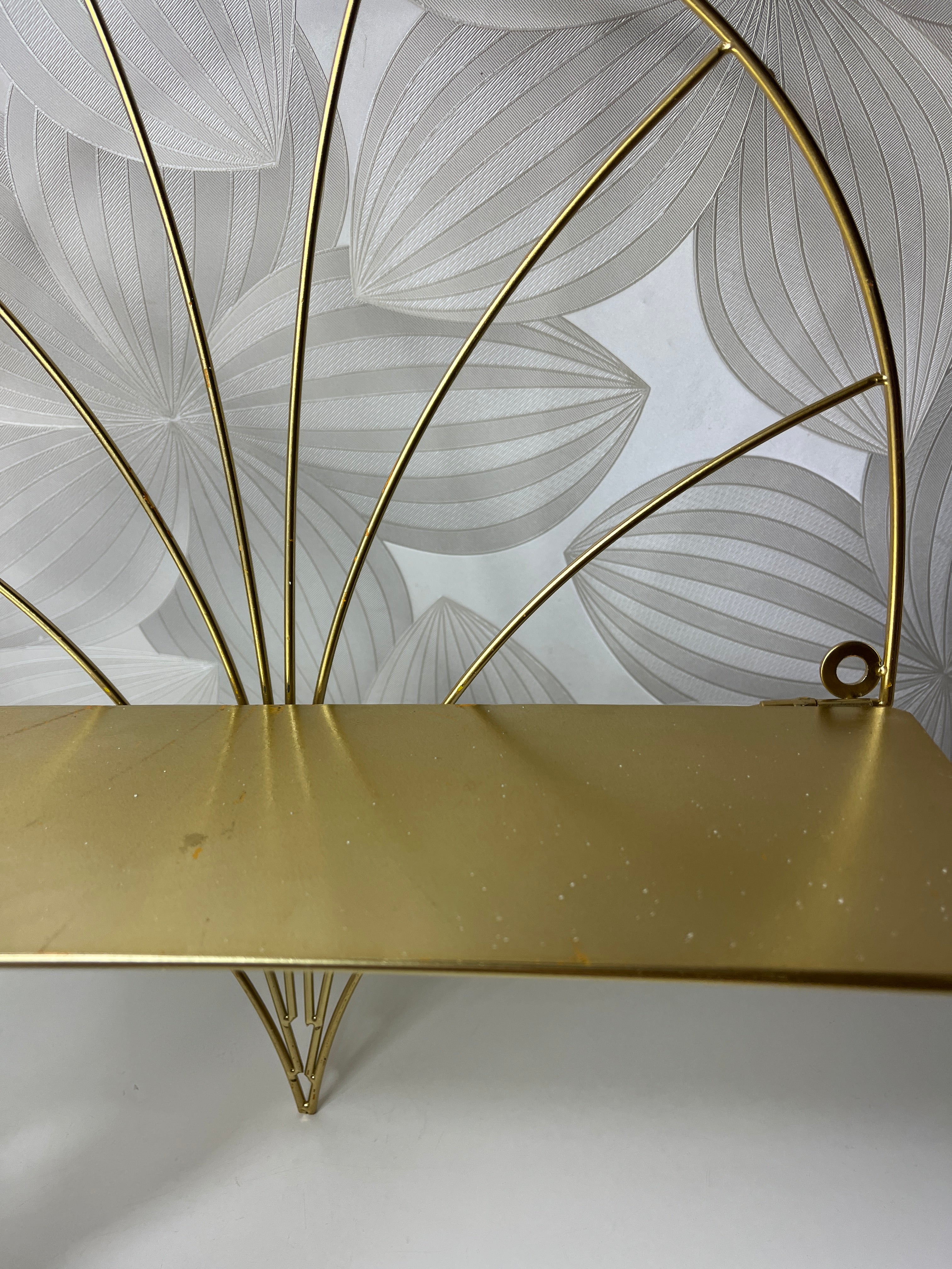 Auksinės spalvos lentyna su metaliniu rėmu