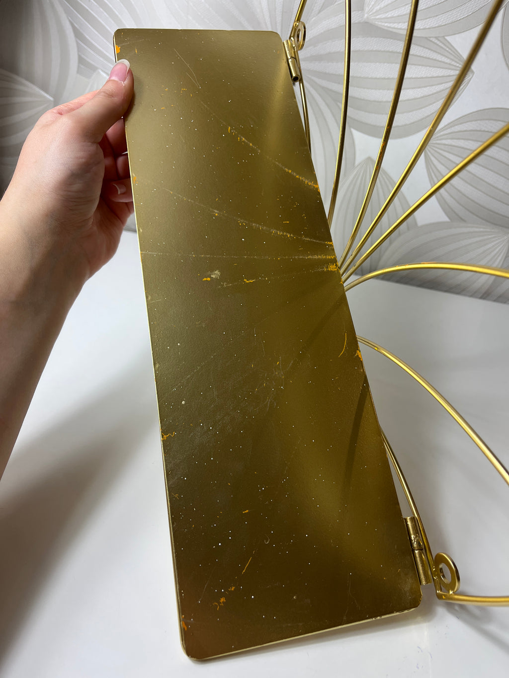 Auksinės spalvos lentyna su metaliniu rėmu